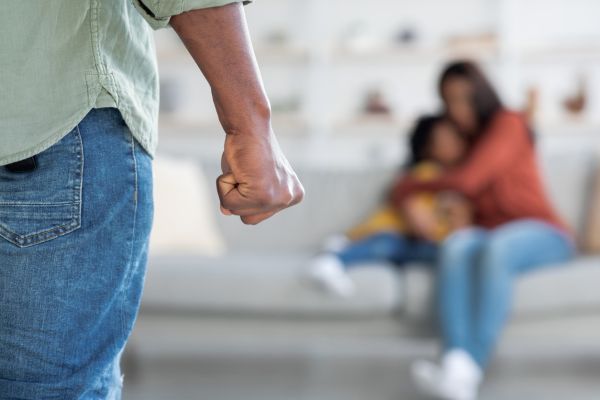 Domestic Violence. African American Man Threatening Wife And Daughter With His Fist