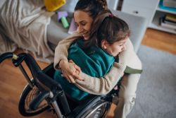 A mother and daughter share a loving embrace at home.